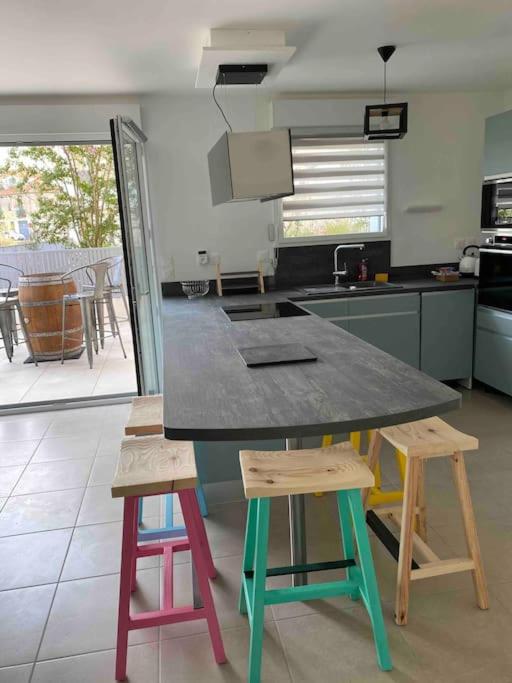une cuisine avec une table et des tabourets colorés dans l'établissement Superbe appartement T3 centre ville Rondelet, à Montpellier