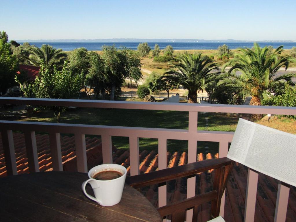 Zafira Retreat في Vatopedi: وجود كوب من القهوة على طاولة في الشرفة