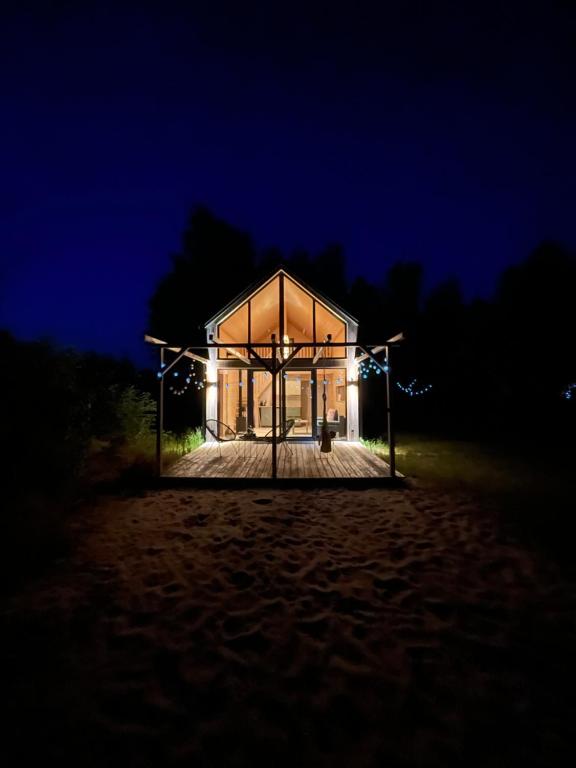 a house on the beach at night at Domki Skandynawskie nad Pilicą, Biała Góra, mazowieckie in Krzemień