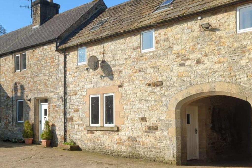 an old stone building with an archway in front of it at The cottage in Alston