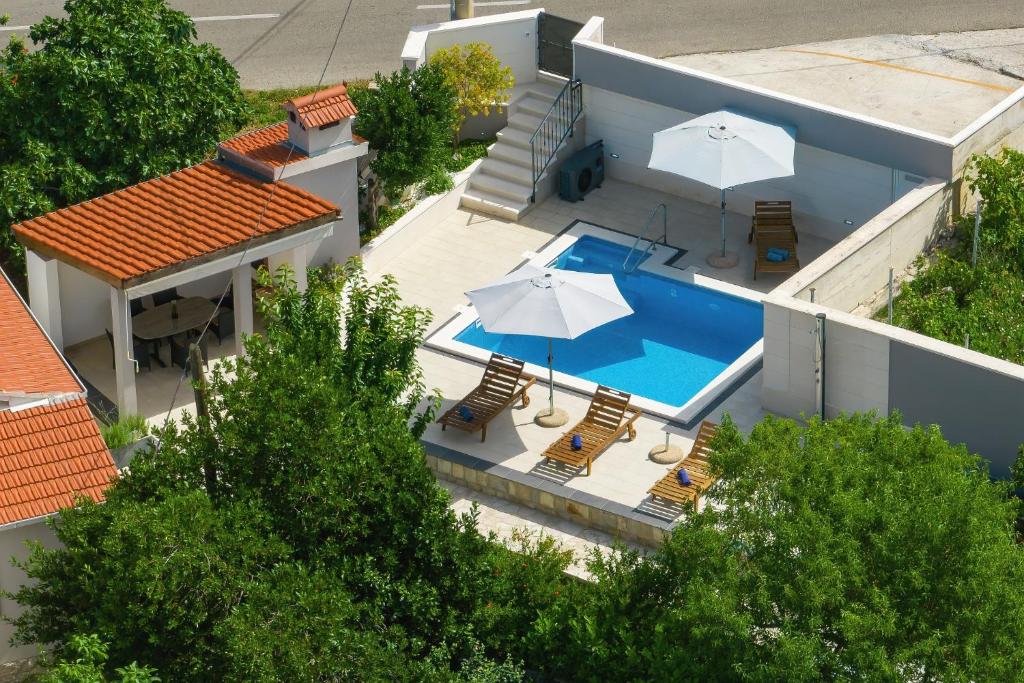 una vista aérea de una casa con piscina y sombrillas en Villa Ella - swimming pool, garden, baby friendly, en Bast