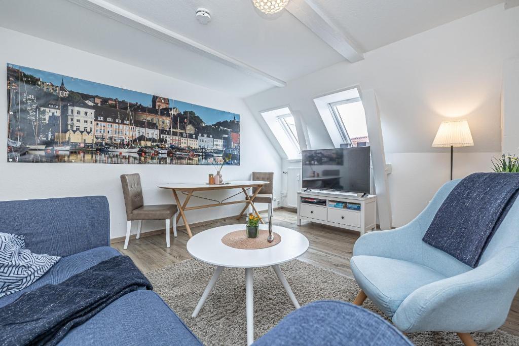 フレンスブルクにあるfewo1846 - Im Sonnenhof - komfortable 2-Zimmer-Wohnung im Stadtzentrumのリビングルーム(青い椅子2脚、テーブル付)