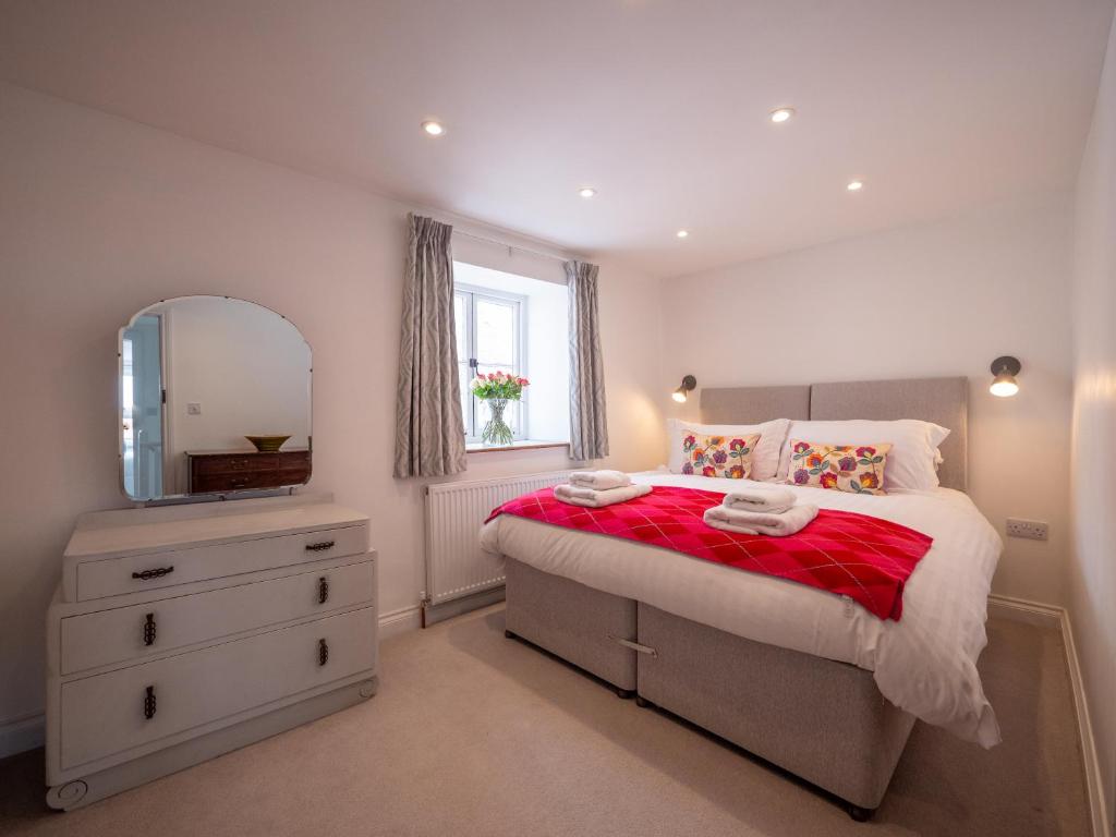 um quarto com uma cama, uma cómoda e um espelho em Blackberry Cottage - Newly renovated cosy cottage em Malborough