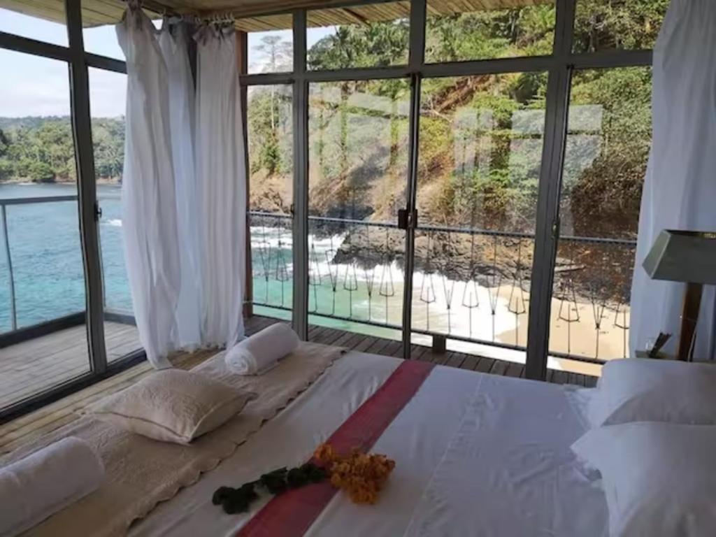 a bedroom with a large bed with a large window at Mawo house in SantʼAna