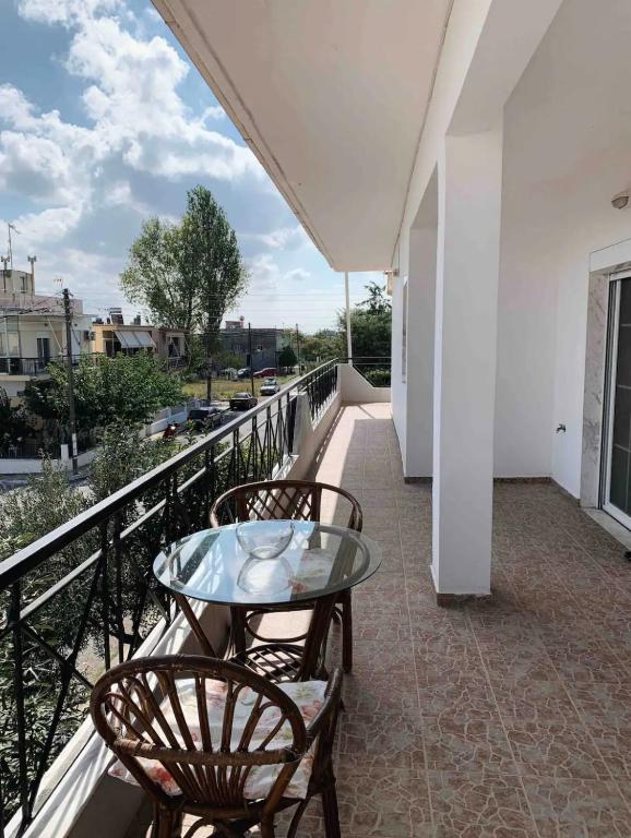 a balcony with a glass table and two chairs at Dimitra House Entire apartment with balcony and view in Pherrai