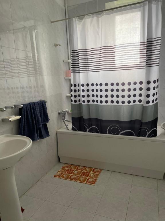 a bathroom with a black and white shower curtain at Lernarot Guest House 