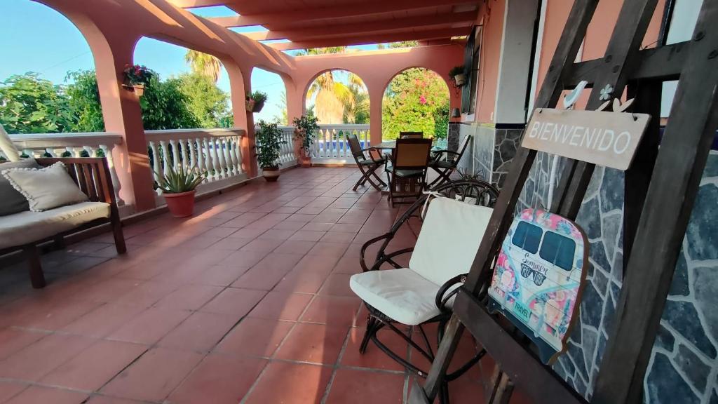 een afgeschermde veranda met stoelen en een tafel bij Villa Pilarín in Málaga