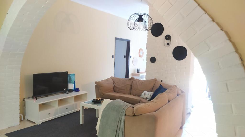 a living room with a couch and a tv at Türkiz Apartman - 5 szobás 13 fős apartmanház 4km a Balaton- Balatonszabadi in Balatonszabadi