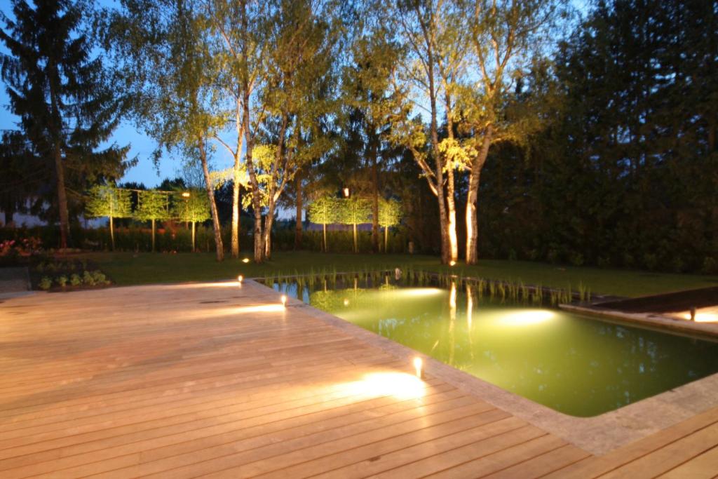 a pool with lights in a backyard at night at B&B White Pearl in Müllerthal