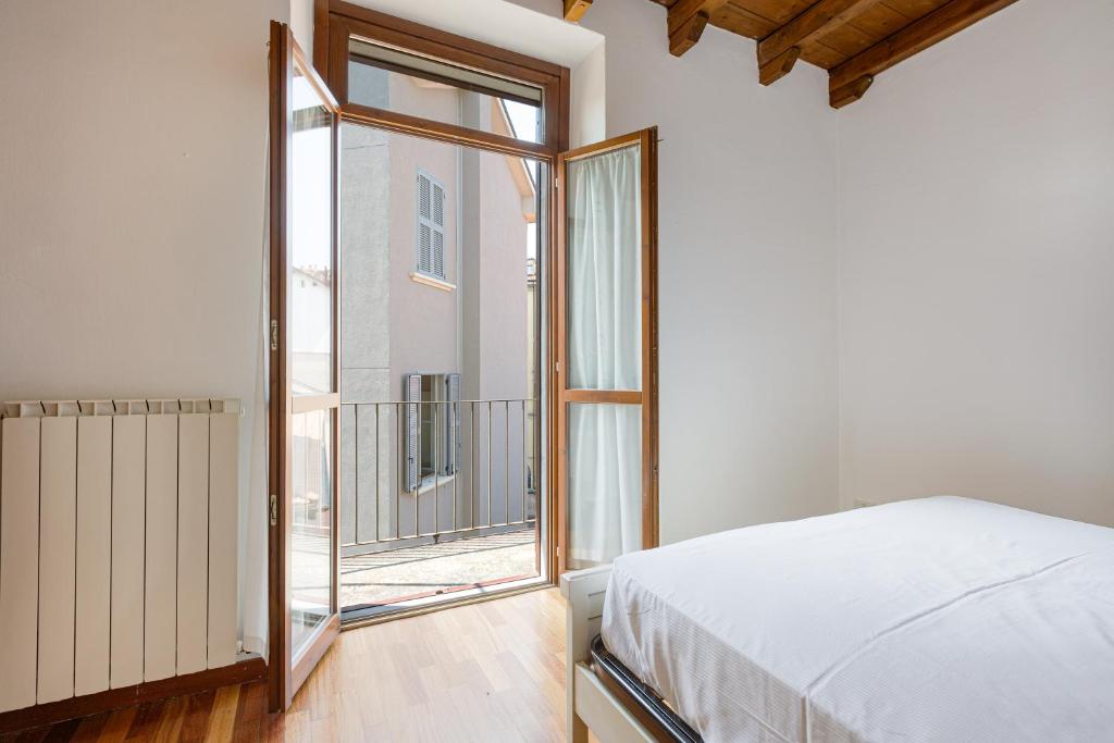 ein Schlafzimmer mit einem Bett und einem großen Fenster in der Unterkunft Porta Romana M3- Cosy apartament in Mailand