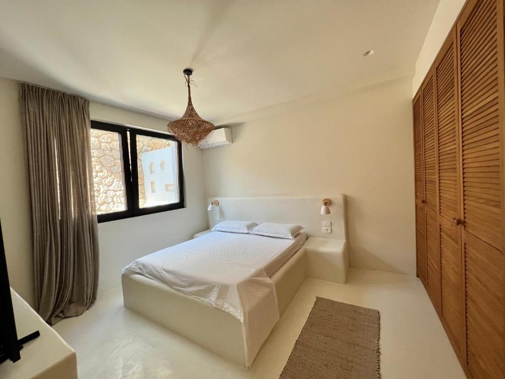 a bedroom with a white bed and a window at White Pearl Villa in Dhërmi