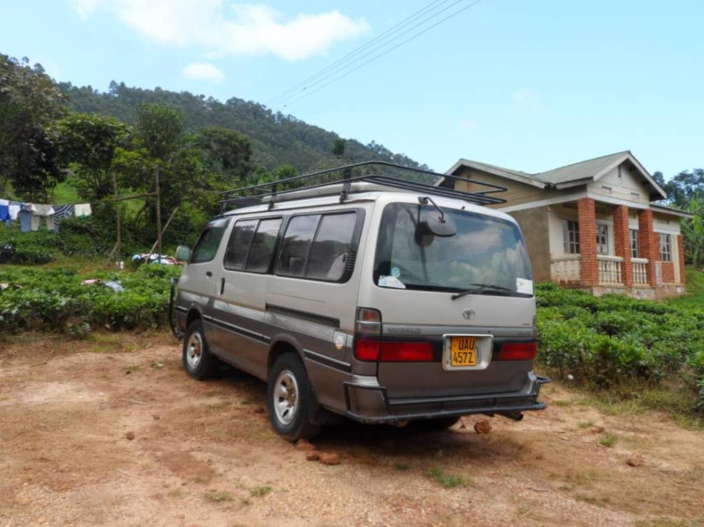 a van parked in front of a house at Buhoma Community Haven lodge 