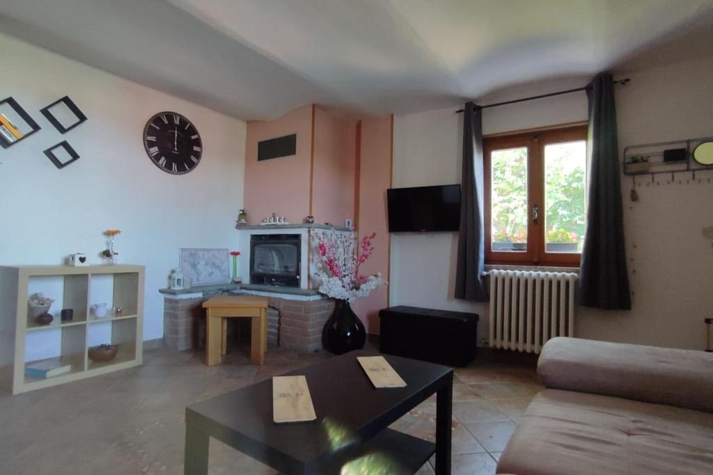 ein Wohnzimmer mit einem Sofa und einer Uhr an der Wand in der Unterkunft La casa di giuda in Vigliano d'Asti