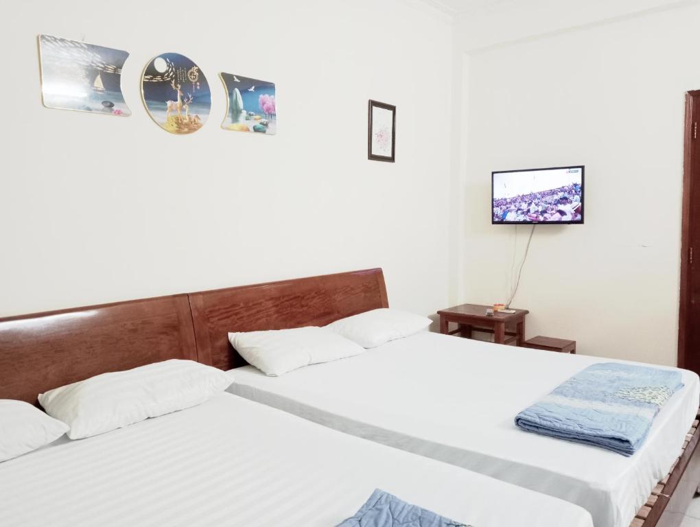 two beds in a room with white walls at Quân Nguyễn in Vung Tau