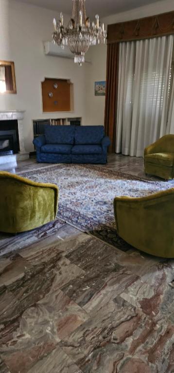 una gran sala de estar con un sofá azul y sillas en BELLO E LUMINOSO, en Florencia
