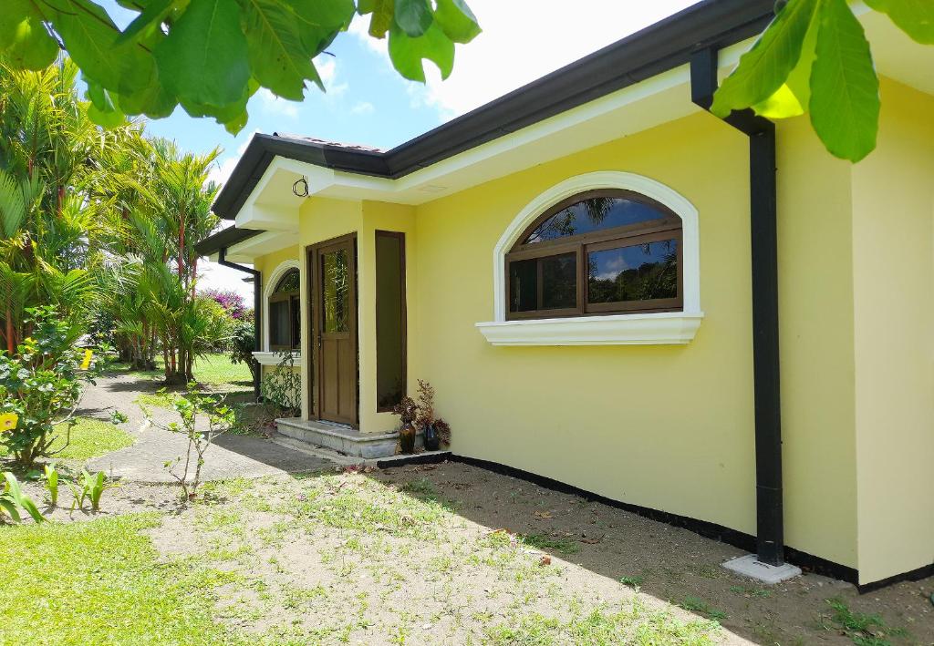 a yellow house with a window and a door at Beautiful Lake Arenal 2 Bed Villa - Plus Communal Pool, Gym, Massage in Tronadora