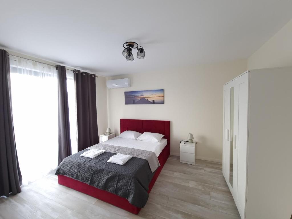 a bedroom with a bed and a large window at Апартаменти Жилищна сграда Орех in Varna City