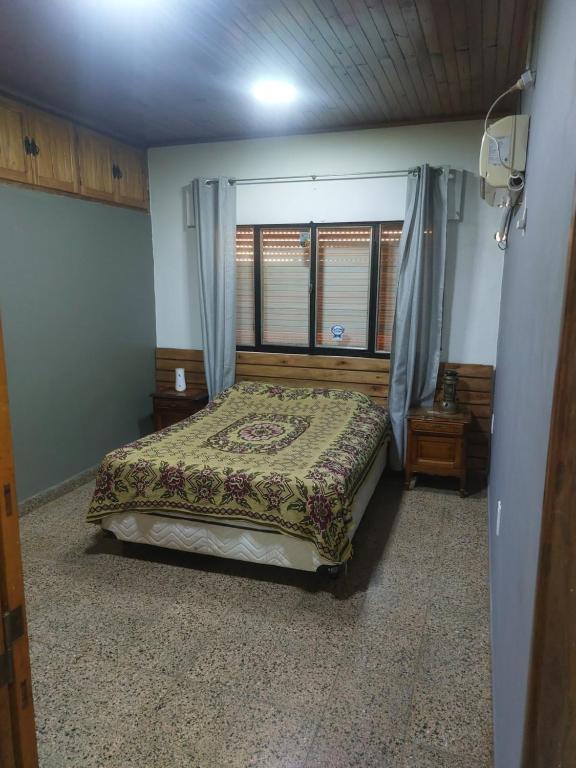 1 dormitorio con cama y ventana en HOSTEL DEL HERRERO en Apóstoles