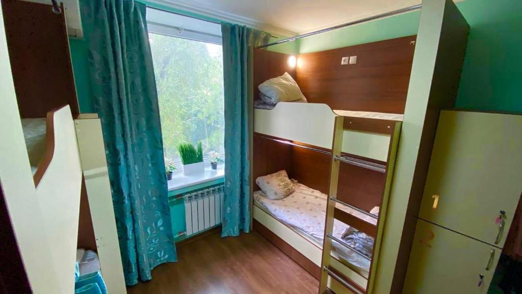 Cette petite chambre comprend des lits superposés et une fenêtre. dans l'établissement Golden Square, à Almaty