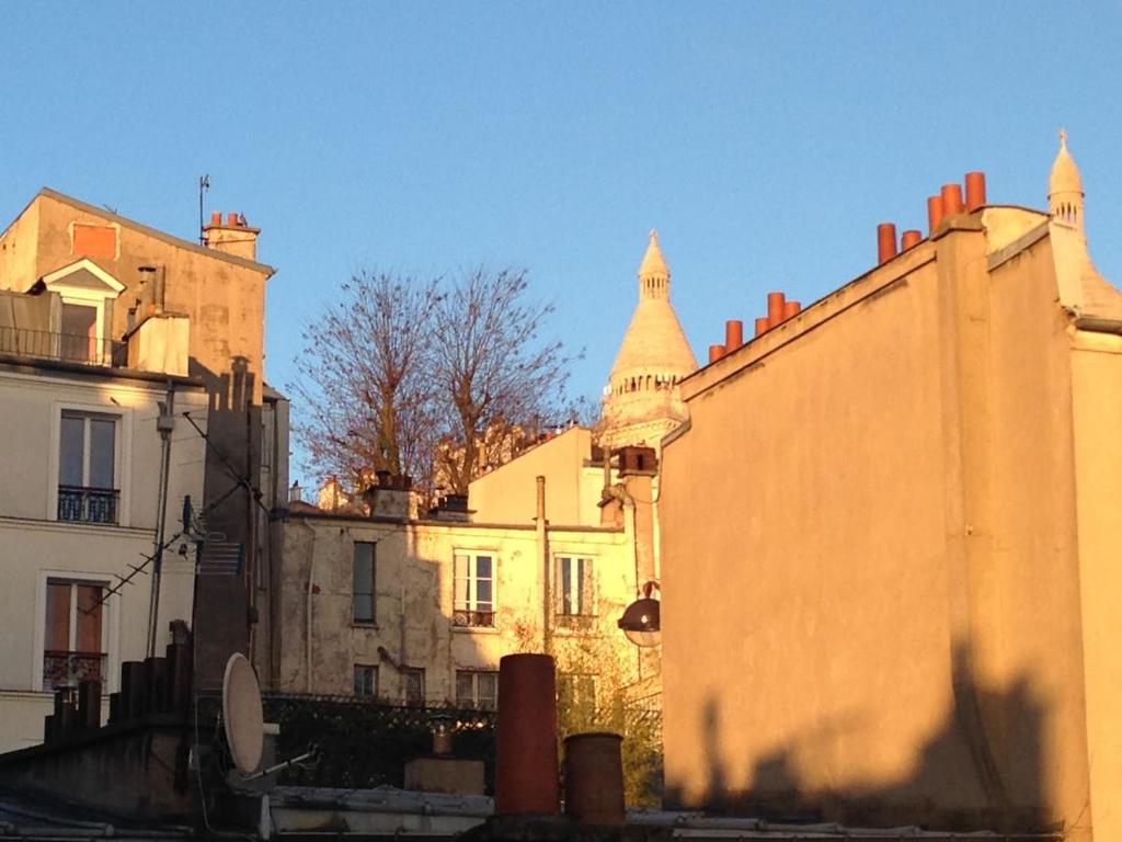 a group of buildings with a tower in the background at Montmartre Bright & Quiet in Paris