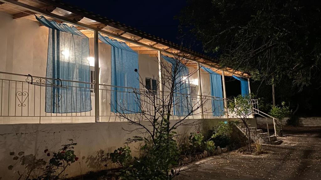 a house with blue curtains on a balcony at night at Chelonaria in Kalamaki