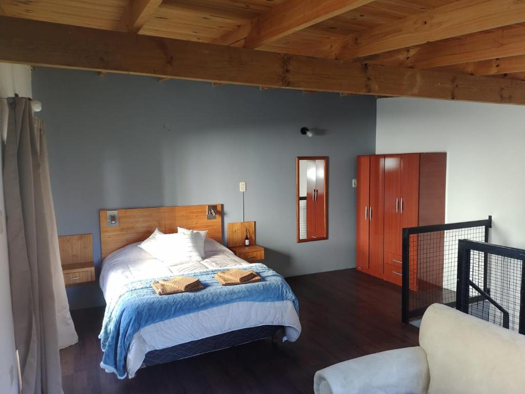 1 dormitorio con cama y techo de madera en Departamentos Ventana en Sierra de la Ventana