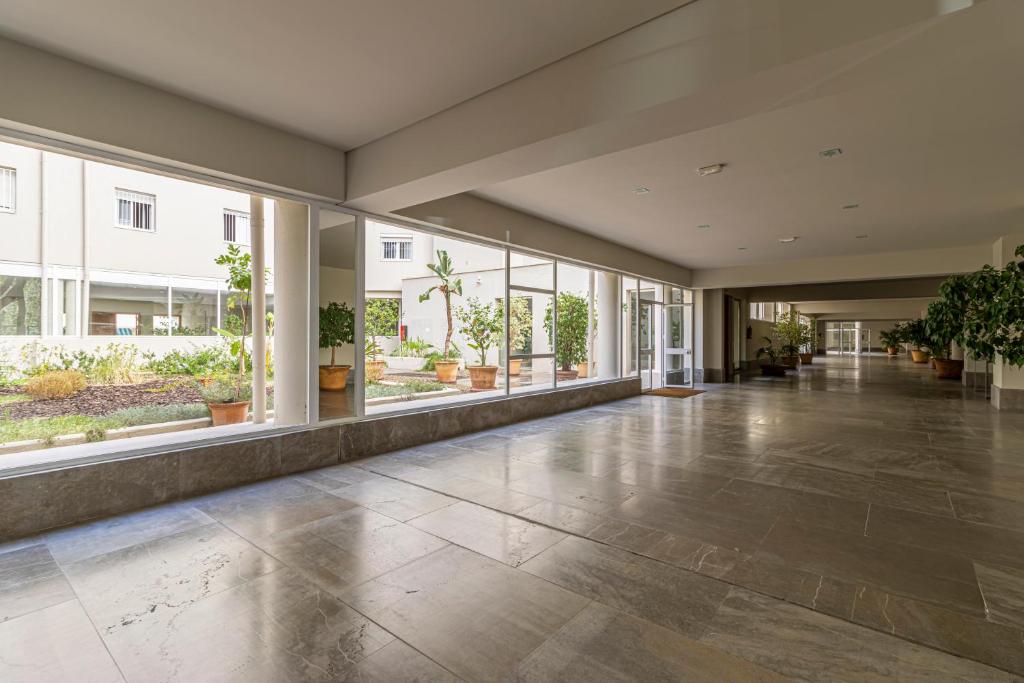 een lege lobby met grote ramen en planten bij Allo Apartments Santo Domingo 2 Habitaciones - Parking in Jerez de la Frontera