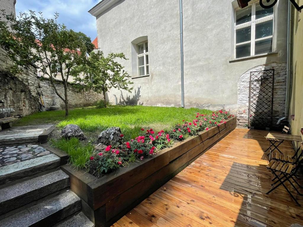 een tuin met roze bloemen in een houten plant bij Historic Apartment with Private Garden in Old Town in Tallinn