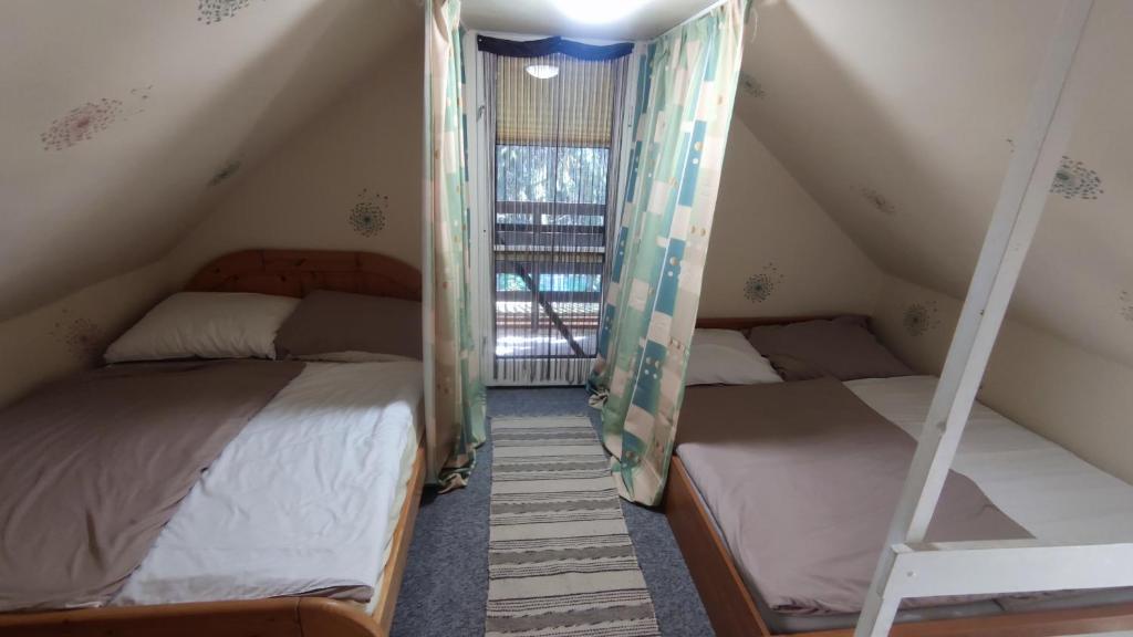 two bunk beds in a room with a window at T-Lak Vendégház Tiszalök in Tiszalök