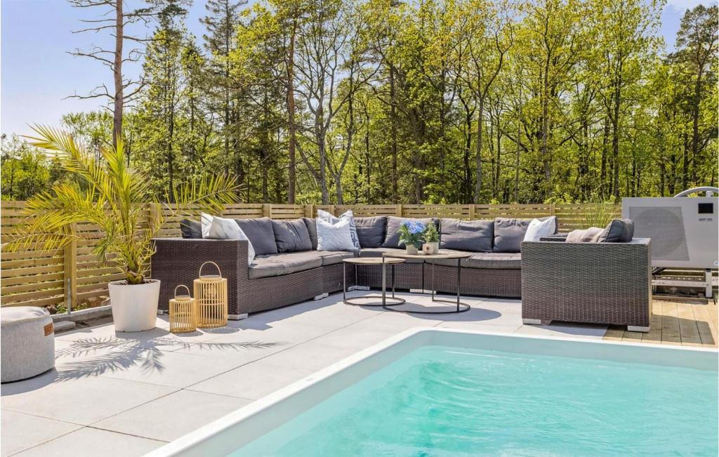 a patio with a couch and a swimming pool at Nice Home In Frvik With Wifi, 3 Bedrooms And Outdoor Swimming Pool in Færvik