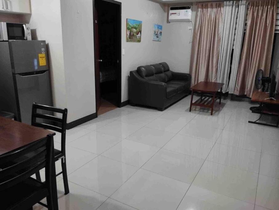 a living room with a couch and a table at Spacious 1 bedroom unit in Araneta Center Cubao in Manila