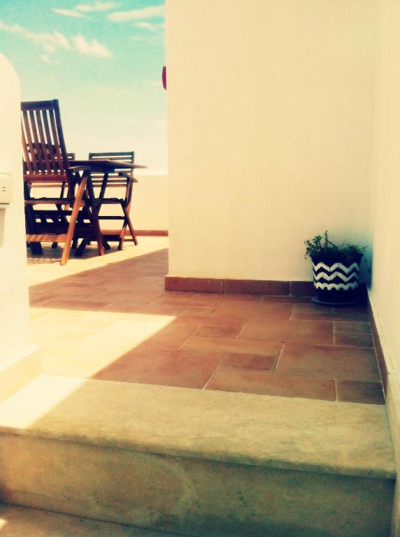 a patio with a table and chairs on a porch at Gaia Serifos Apartments in Rámos