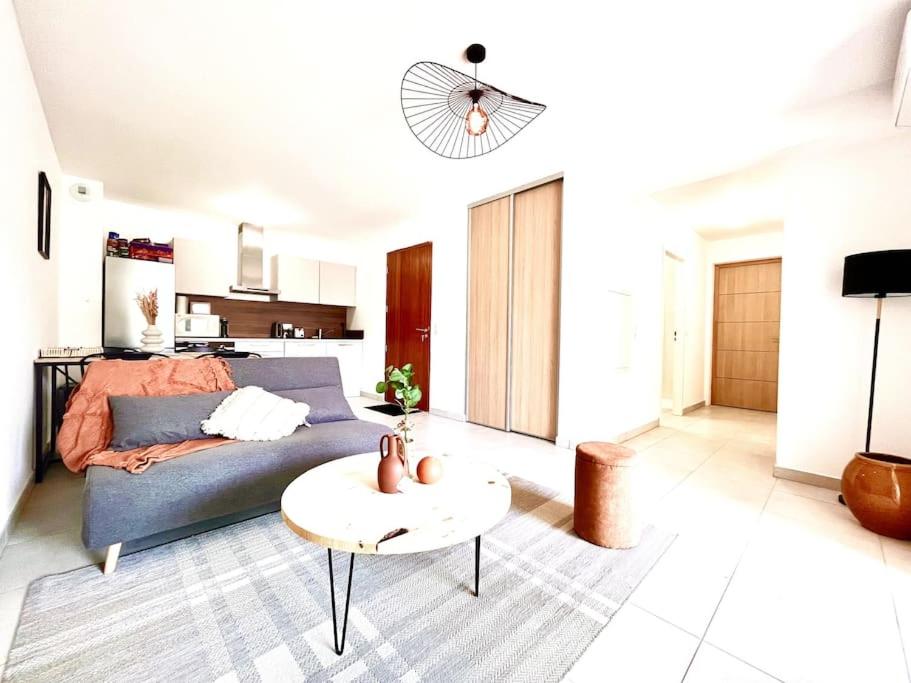 una sala de estar con un sofá y una mesa en Appartement Terrasse St Florent, en Saint-Florent