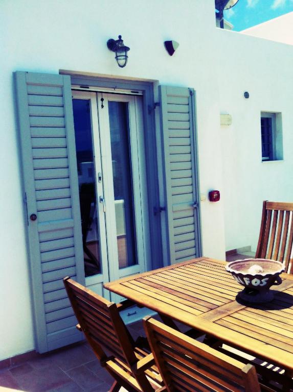 a wooden table and chairs on a patio at Gaia Serifos Apartments in Rámos