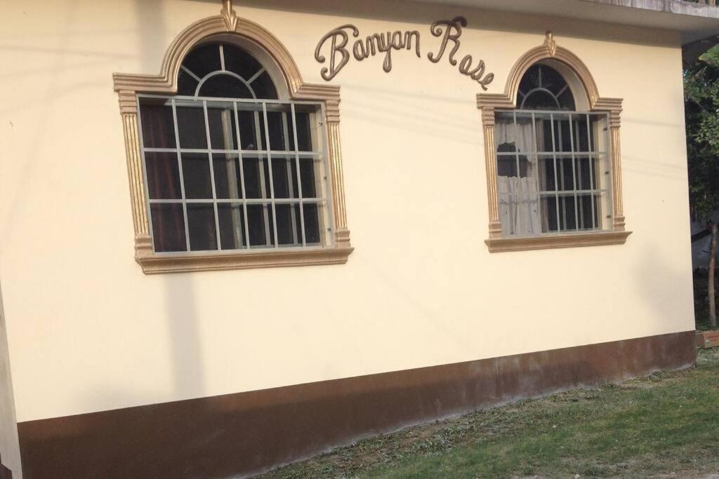 two windows on the side of a building at Banyan Rose in Orange Walk