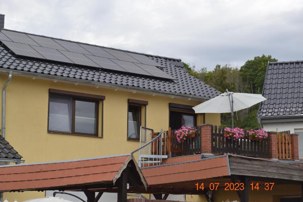 ein Haus mit Sonnenkollektoren auf dem Dach in der Unterkunft Ferienwohnung mit Ausblick in Wimmelburg in Wimmelburg