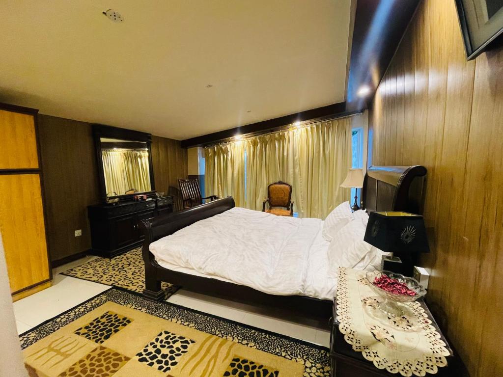 a bedroom with a large bed and a desk at Misty Mountain in Murree