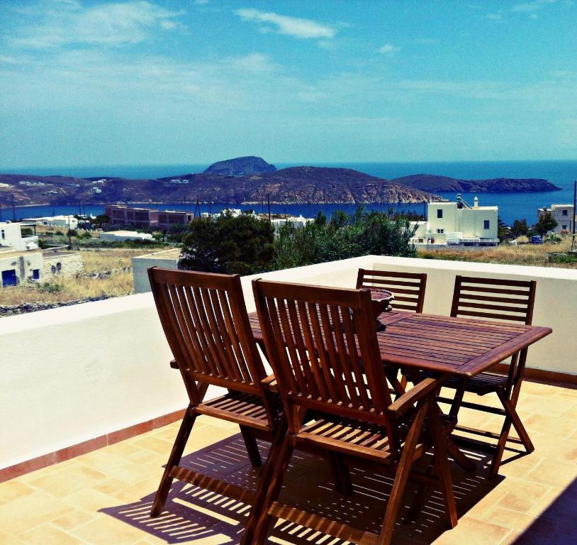 a wooden table and two chairs on a balcony at Gaia Serifos Apartments in Rámos