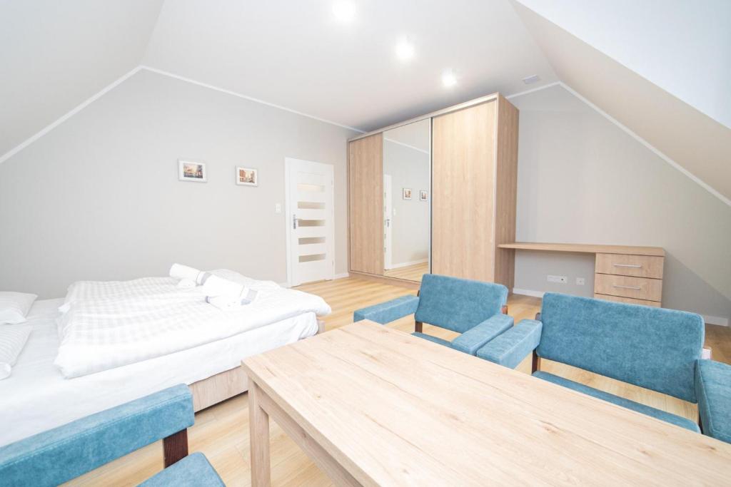 a bedroom with a bed and a table and chairs at VacationClub – Zdrojowa 7 Apartament 11 in Duszniki Zdrój