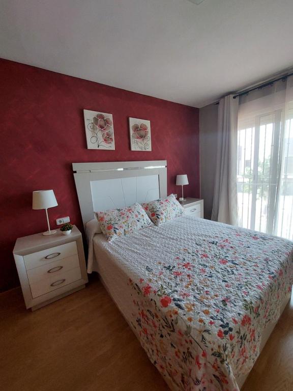 Habitación bonita في سان بييدرو ديل بيناتار: غرفة نوم بسرير وجدار احمر