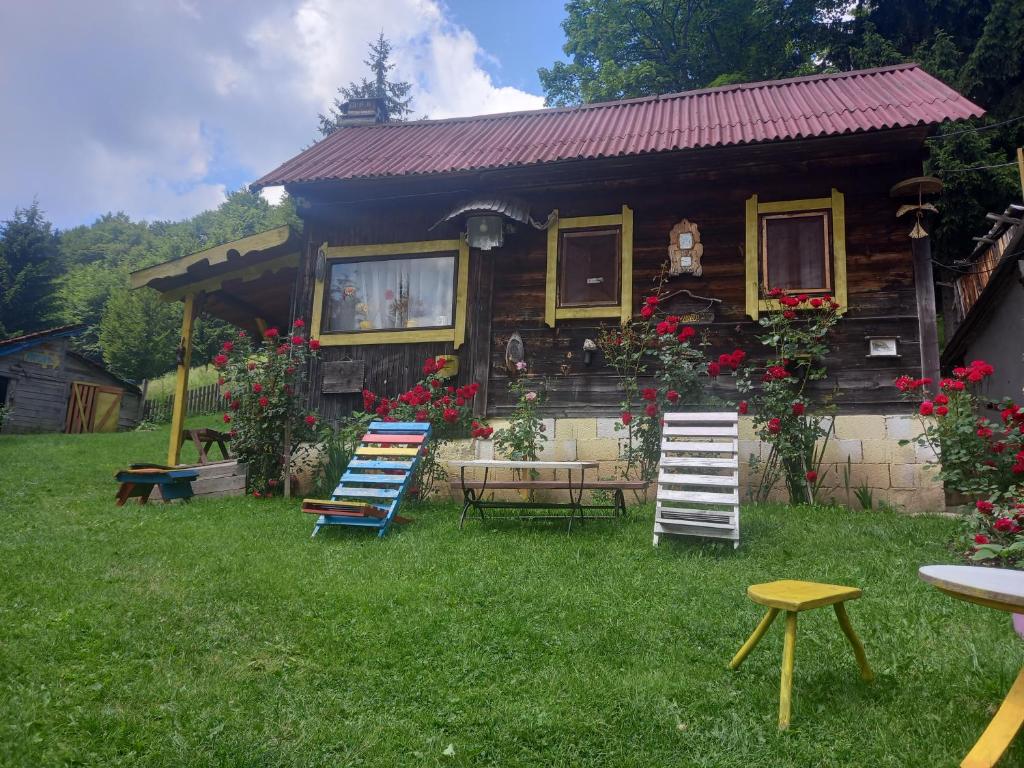 a house with chairs and a table and a house at Vikendice Jasen in Nova Varoš