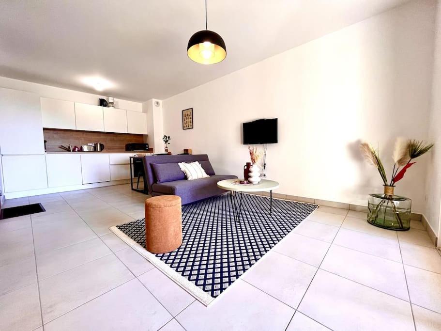 uma sala de estar com um sofá roxo e uma mesa em Appartement Neuf avec Terrasse em Saint-Florent