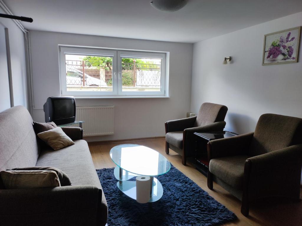 a living room with couches and a tv and a table at Apartament Gosi in Gdynia