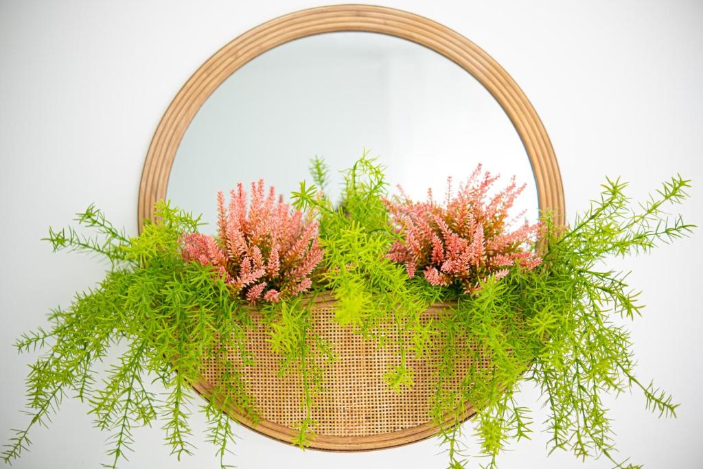 a wicker basket with pink flowers and green plants at Villa Beach in Nazaré