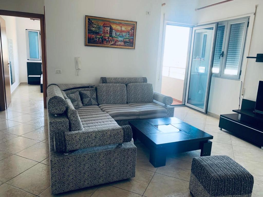 ein Wohnzimmer mit einem Sofa und einem Couchtisch in der Unterkunft H Apartment Vlorë in Vlorë