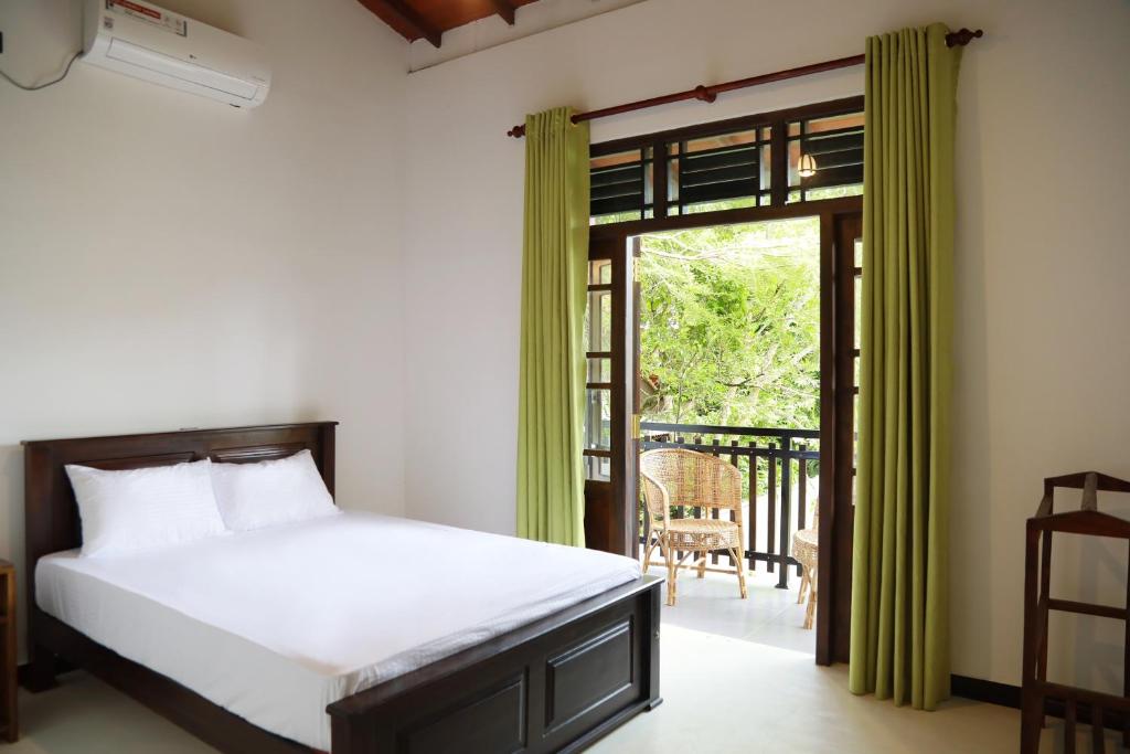 - une chambre avec un lit et une porte coulissante en verre dans l'établissement Iconic Villa, à Ahangama