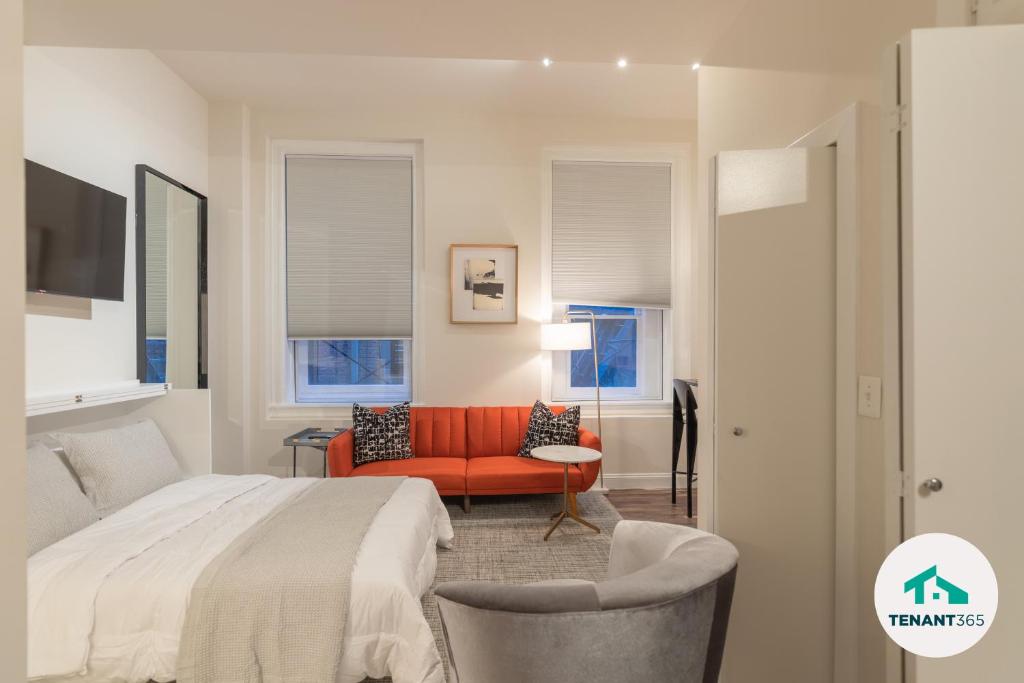 um quarto com uma cama e um sofá vermelho em Inner Harbor's Best Luxury Furnished Apartments apts em Baltimore