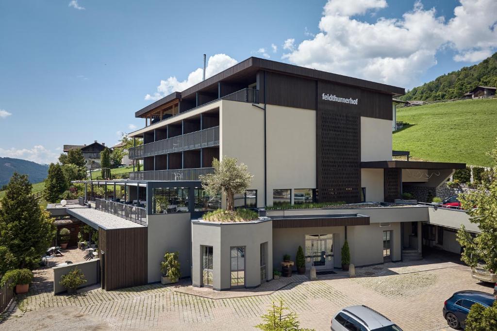 a building with a car parked in front of it at Vinumhotel Feldthurnerhof in Feldthurns