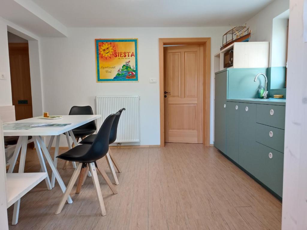 een keuken en eetkamer met een tafel en stoelen bij Siesta apartment Bled in Bled