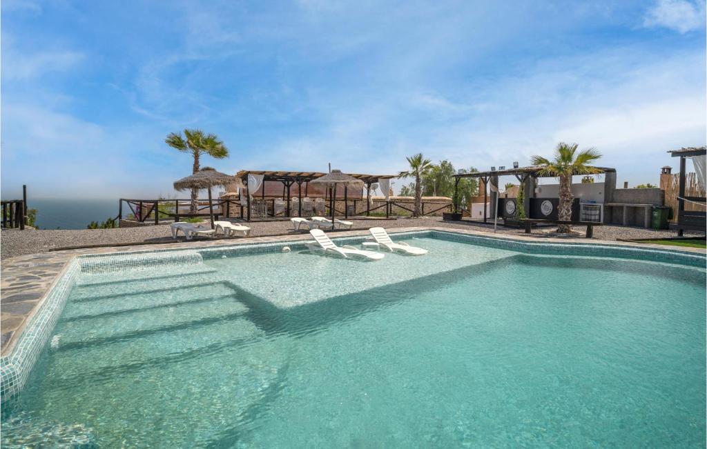 阿德拉的住宿－Nice Home In Adra With Private Swimming Pool, Can Be Inside Or Outside，一个带椅子和遮阳伞的游泳池